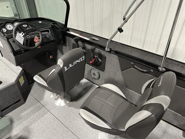 Slide: The Image of 2025 Lund 1875 Fisherman Sport interior with two swivel seats and dashboard controls. - 12