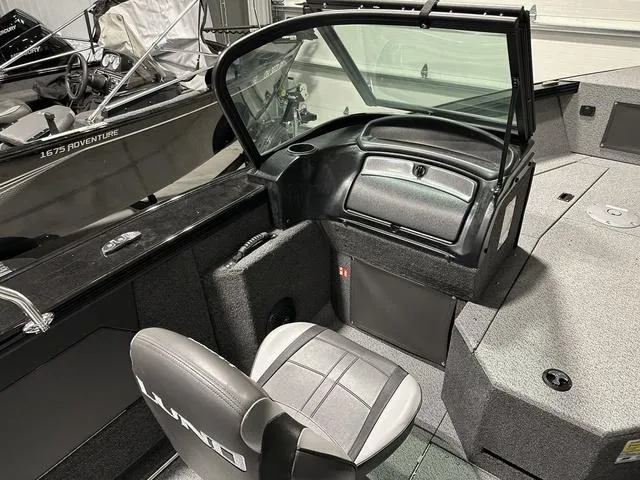 Slide: The Image of 2025 Lund 1875 Fisherman Sport boat interior with seating and dashboard. - 13