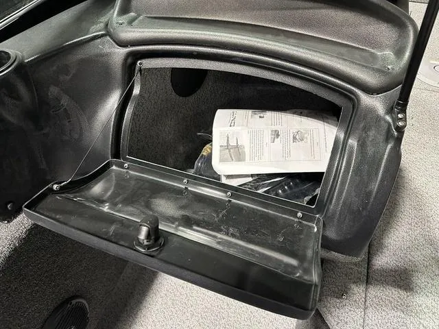 Slide: The Image of Open storage compartment in 2025 Lund 1875 Fisherman Sport boat, showing manual inside. - 15