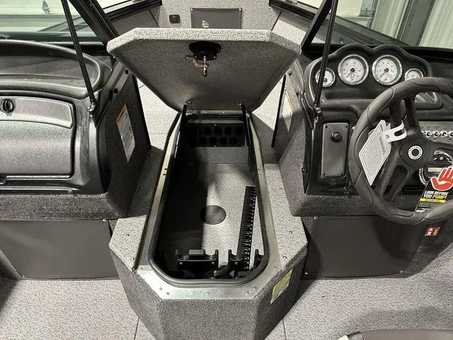 Slide: The Image of 2025 Lund 1875 Fisherman Sport interior with open storage compartment and dashboard view. - 19