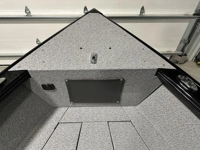 Slide: The Image of 2025 Lund 1875 Fisherman Sport boat interior, featuring a textured deck and storage compartment. - 21