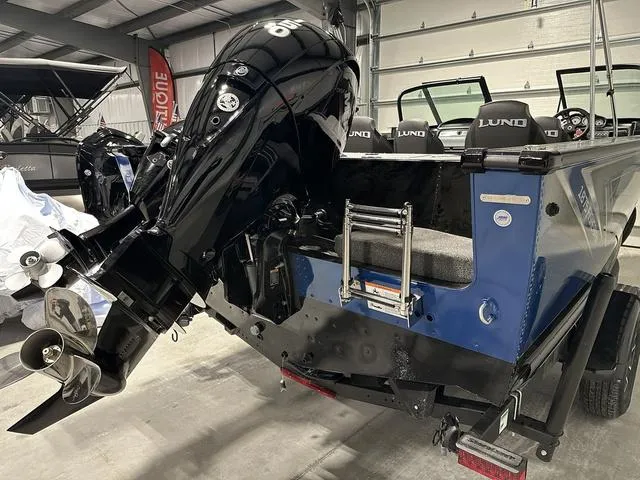 Slide: The Image of 2025 Lund 1875 Fisherman Sport boat with powerful outboard motor in a garage setting. - 5