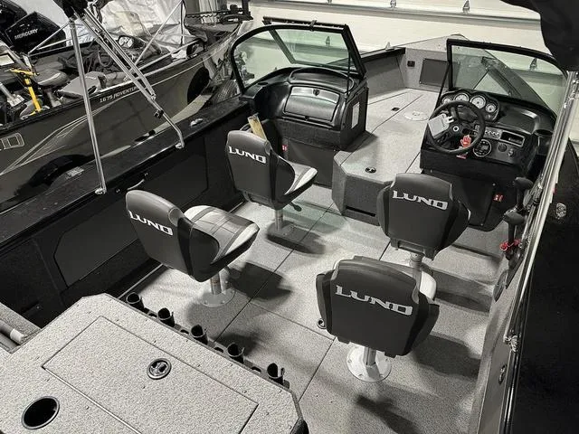 Slide: The Image of 2025 Lund 1875 Fisherman Sport boat interior with four seats and modern dashboard. - 7