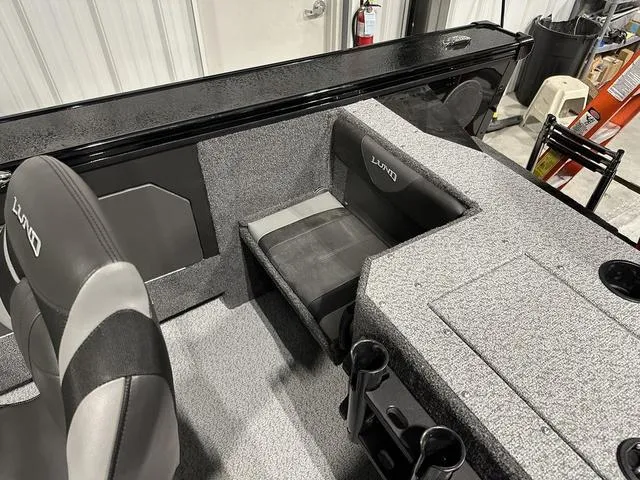 Slide: The Image of 2025 Lund 1875 Fisherman Sport interior with gray seating and storage compartments. - 9