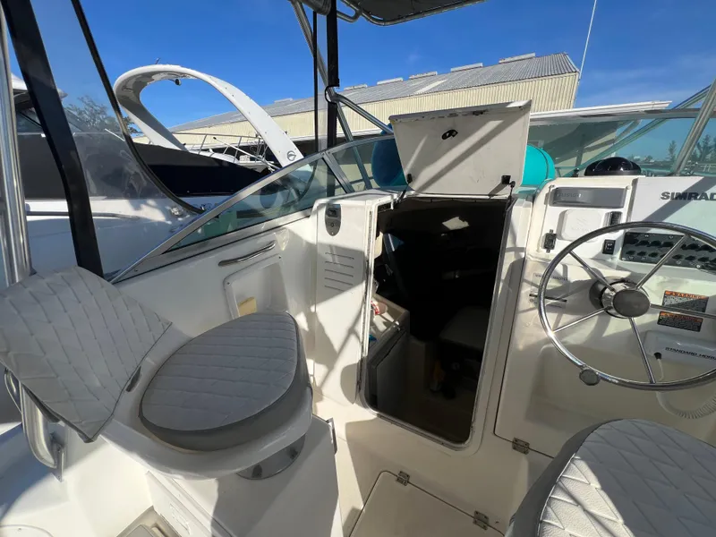 Slide: The Image of 2000 Robalo 2440 Walkaround boat interior with steering wheel and seating. - 12