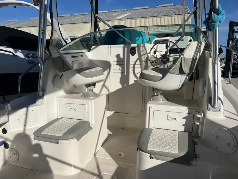 Slide: The Image of 2000 Robalo 2440 Walkaround boat interior with dual seats and steering wheel. - 13