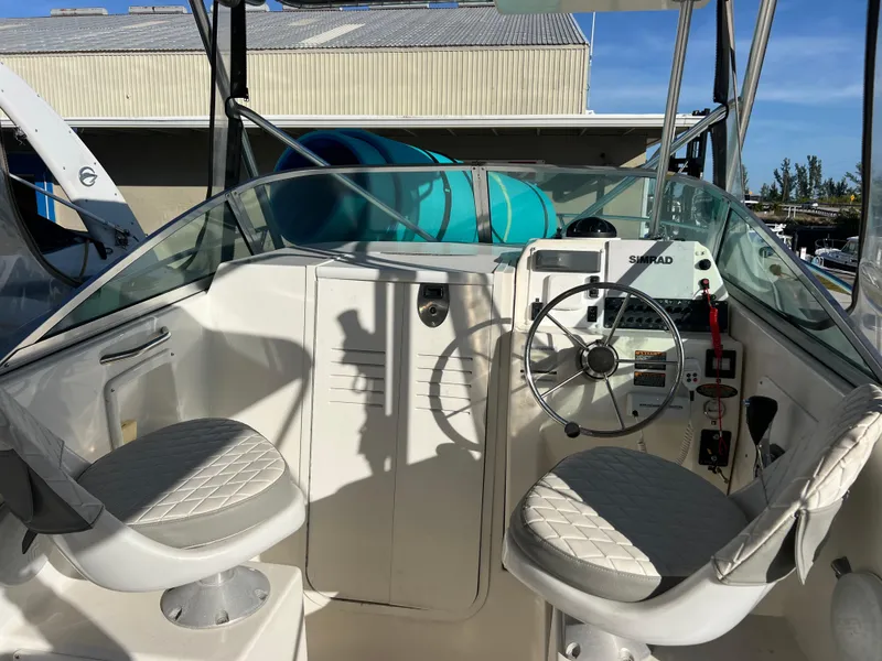 Slide: The Image of 2000 Robalo 2440 Walkaround boat cockpit with dual seats and steering wheel. - 16