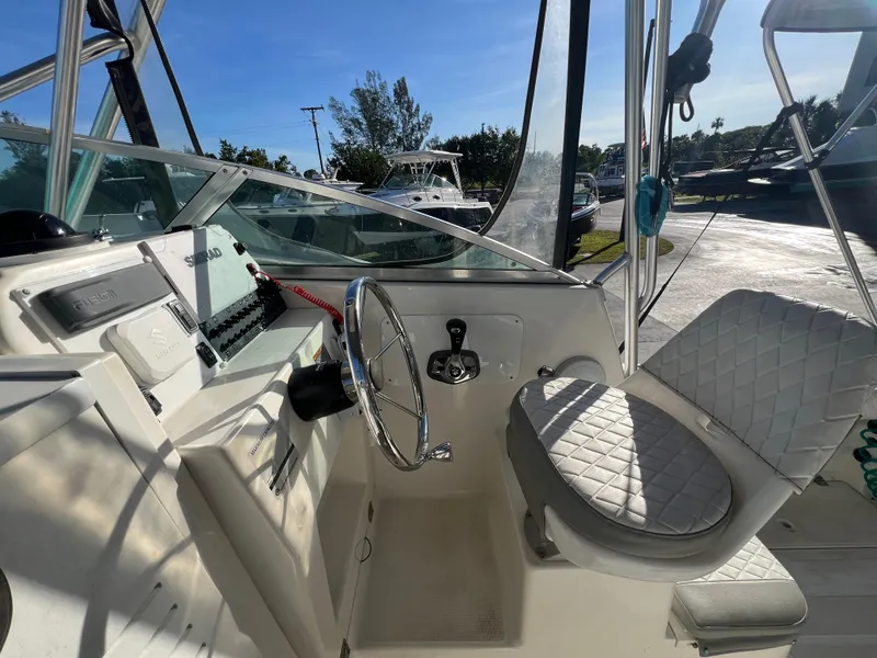Slide: The Image of 2000 Robalo 2440 Walkaround boat interior with steering wheel and captain's chair. - 17