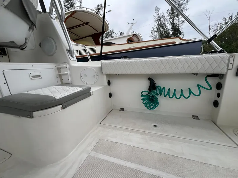 Slide: The Image of 2000 Robalo 2440 Walkaround boat interior with seating and coiled hose. - 20