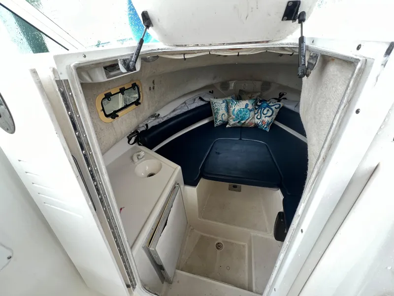 Slide: The Image of 2000 Robalo 2440 Walkaround cabin interior with seating and small sink. - 27