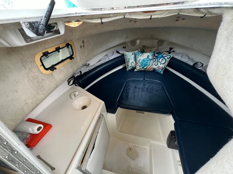 Slide: The Image of Interior of 2000 Robalo 2440 Walkaround boat with blue seating and decorative pillows. - 29