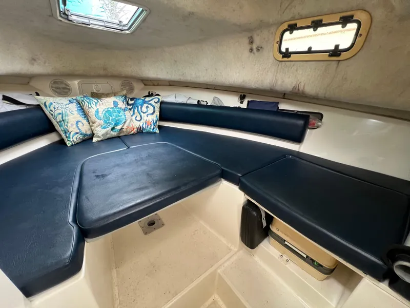 Slide: The Image of Interior cabin of 2000 Robalo 2440 Walkaround with blue seating and decorative pillows. - 30