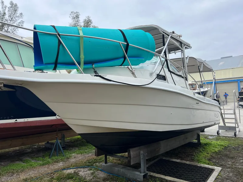 Slide: The Image of 2000 Robalo 2440 Walkaround boat on trailer with blue tarp. - 5