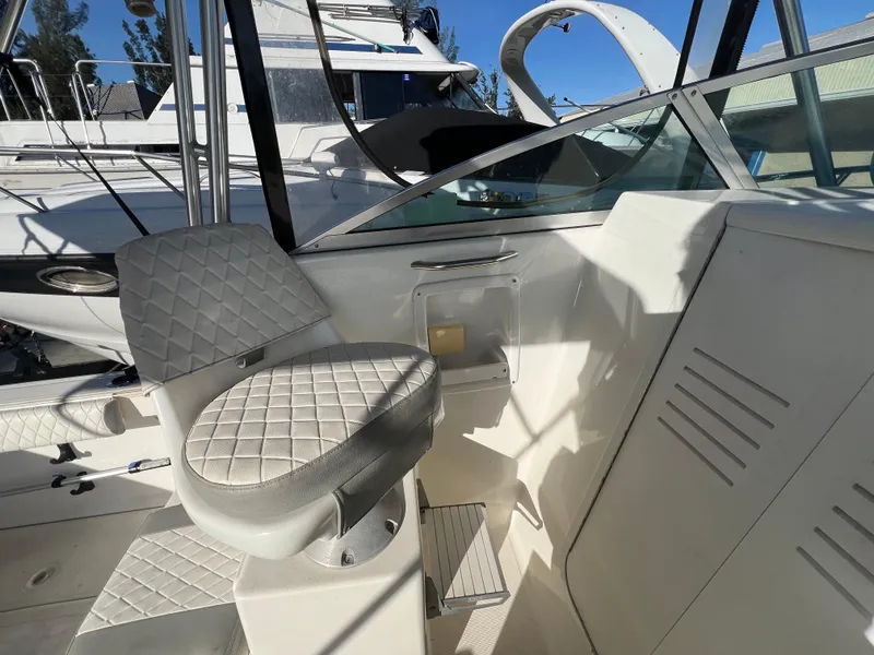 Slide: The Image of 2000 Robalo 2440 Walkaround boat interior with white seating and helm area. - 9