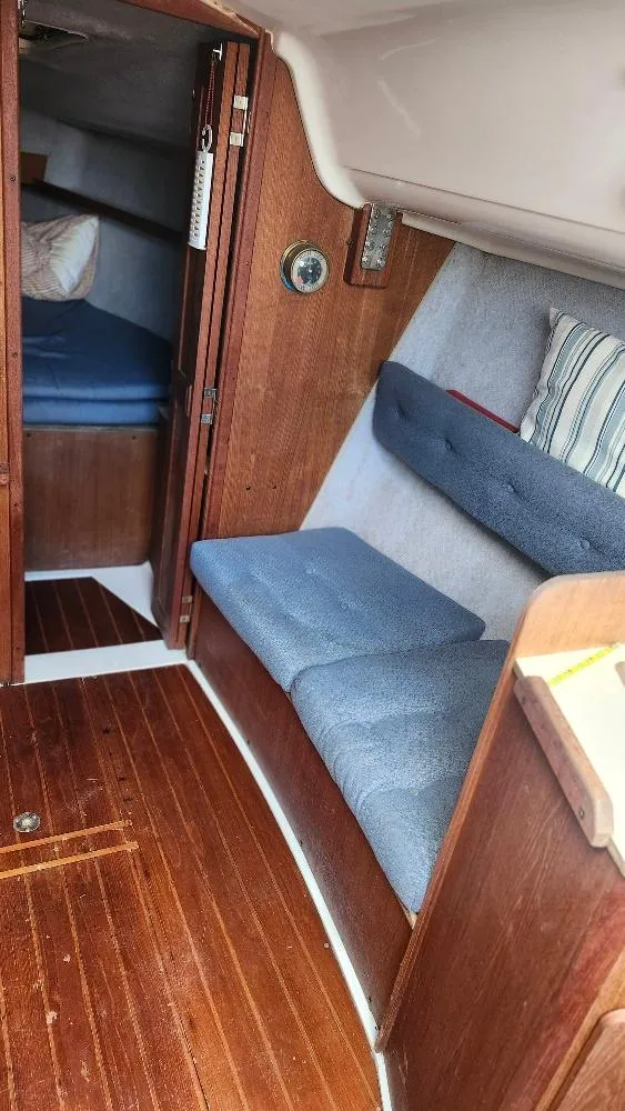 Slide: The Image of Interior of 1987 Hunter 26.5 sailboat with wooden finish and blue cushions. - 11