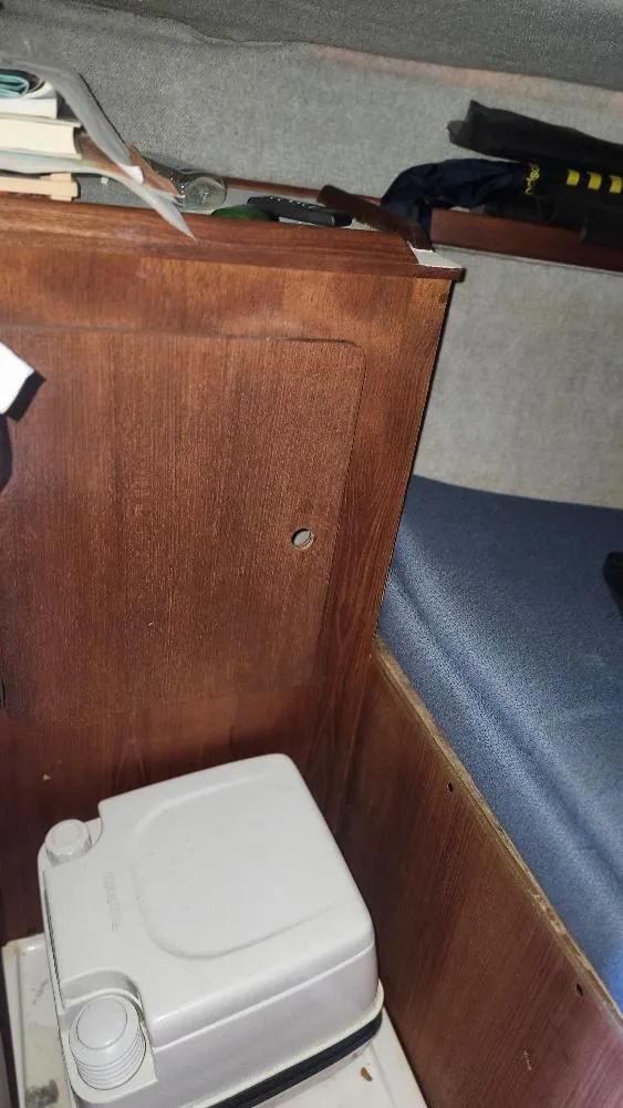 Slide: The Image of Interior of 1987 Hunter 26.5 sailboat with compact toilet and wooden cabinetry. - 13