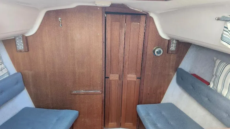 Slide: The Image of Interior of 1987 Hunter 26.5 sailboat with wooden paneling and blue seating. - 20