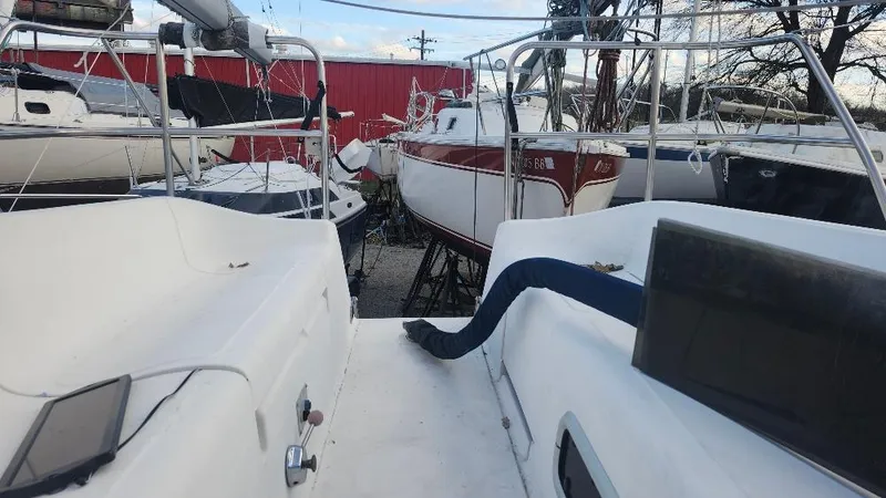 Slide: The Image of 1987 Hunter 26.5 sailboat in storage yard, surrounded by other boats. - 22