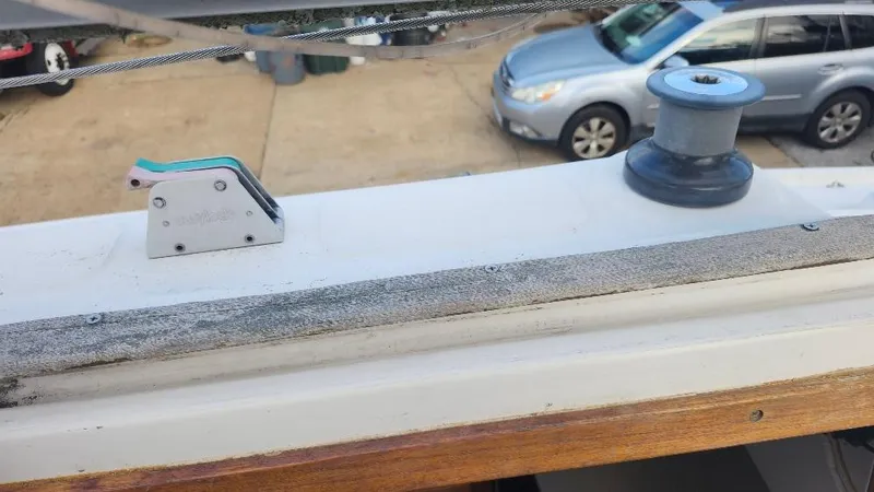 Slide: The Image of Sailboat deck with winch and cleat, Hunter 26.5, 1987 model, parked cars in background. - 23