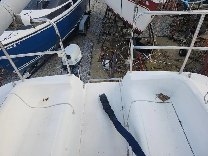 Slide: The Image of 1987 Hunter 26.5 sailboat deck with railing, docked alongside other boats. - 27
