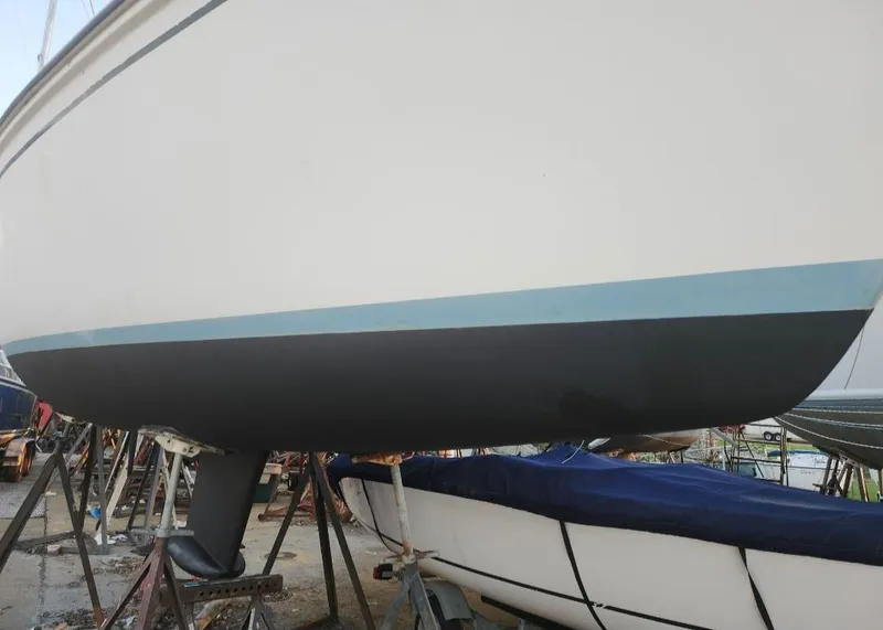 Slide: The Image of 1987 Hunter 26.5 sailboat hull on stands, in a boatyard. - 31