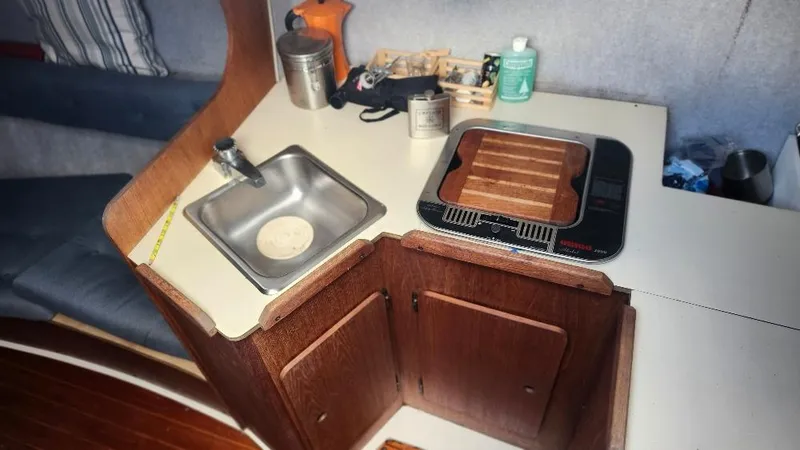 Slide: The Image of Compact kitchen area in a 1987 Hunter 26.5 sailboat with sink and stove. - 7