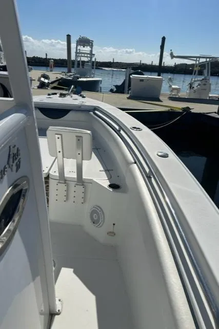 Slide: The Image of 2014 Sea Hunt Gamefish 27 boat docked with forward seating, sunny marina view. - 16