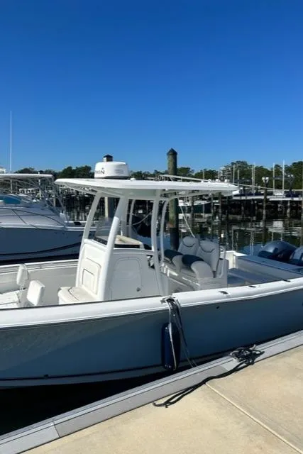 Slide: The Image of 2014 Sea Hunt Gamefish 27 boat docked at marina under clear blue sky. - 2