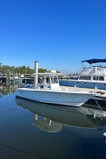 Slide: The Image of 2014 Sea Hunt Gamefish 27 boat docked in marina under clear blue sky. - 4