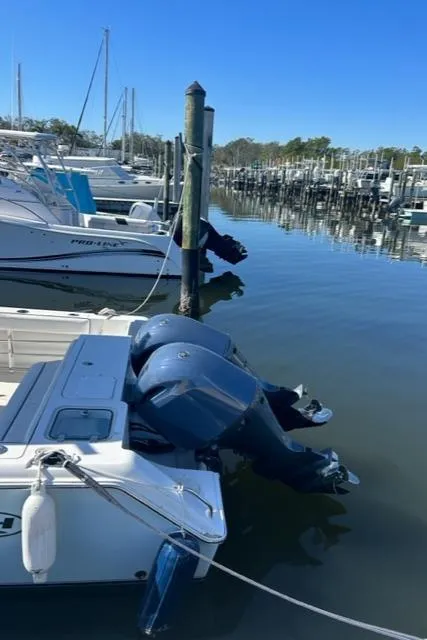 Slide: The Image of 2014 Sea Hunt Gamefish 27 boat docked in a marina with twin outboard motors. - 5