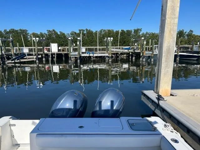 Slide: The Image of 2014 Sea Hunt Gamefish 27 at dock with twin engines, calm water, and clear sky. - 7