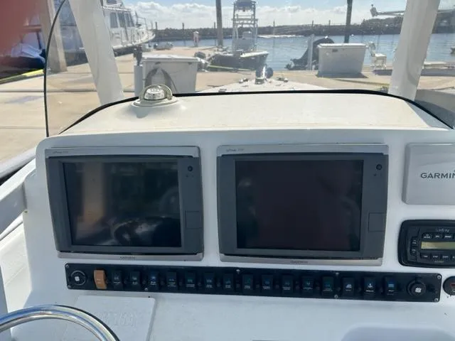 Slide: The Image of 2014 Sea Hunt Gamefish 27 dashboard with dual screens and Garmin system at marina. - 9