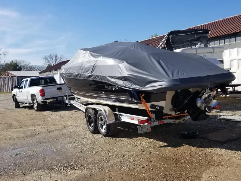 Slide: The Image of Covered 2010 Monterey 254FS boat on trailer, hitched to a white truck. - 10