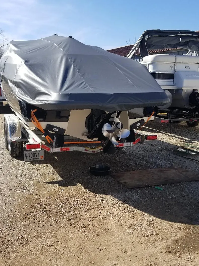 Slide: The Image of 2010 Monterey 254FS boat covered on trailer, parked outdoors. - 13