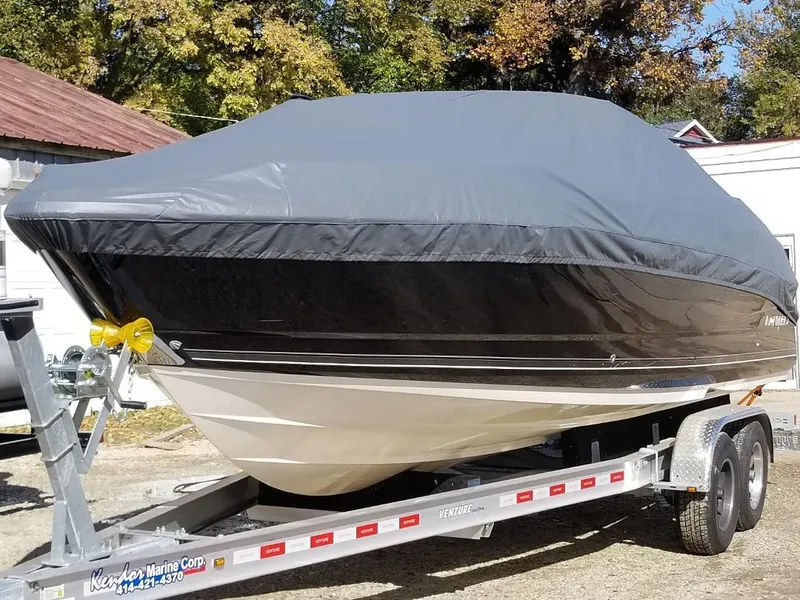 Slide: The Image of 2010 Monterey 254FS boat covered on a trailer, parked outdoors. - 3