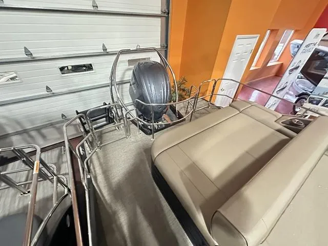 Slide: The Image of 2025 Bennington 24 LXSB pontoon boat interior with motor, in showroom. - 10