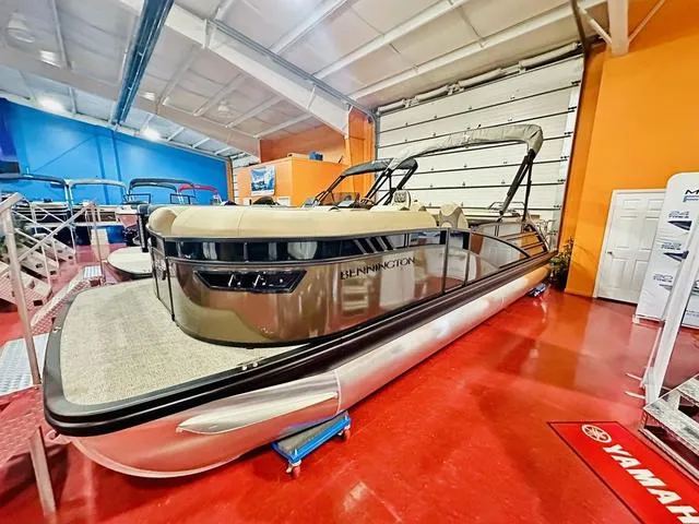 Slide: The Image of 2025 Bennington 24 LXSB pontoon boat in showroom, featuring sleek design and modern amenities. - 17