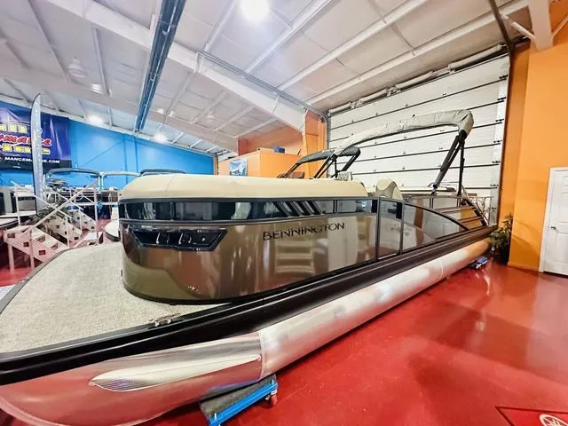 Slide: The Image of 2025 Bennington 24 LXSB pontoon boat in showroom, sleek design, modern features. - 18