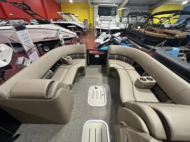 Slide: The Image of 2025 Bennington 24 LXSB pontoon boat interior with beige seating in showroom. - 5