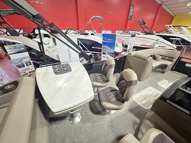 Slide: The Image of 2025 Bennington 24 LXSB boat interior with seating and table in showroom. - 6