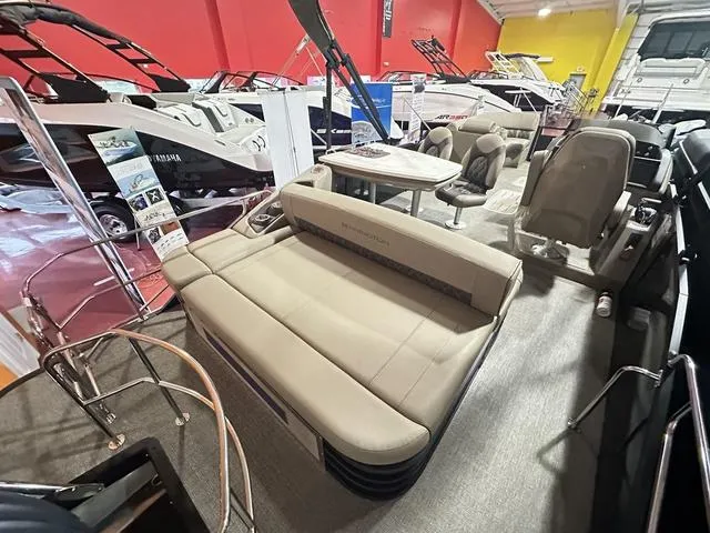 Slide: The Image of 2025 Bennington 24 LXSB pontoon boat interior with seating and table in showroom. - 9