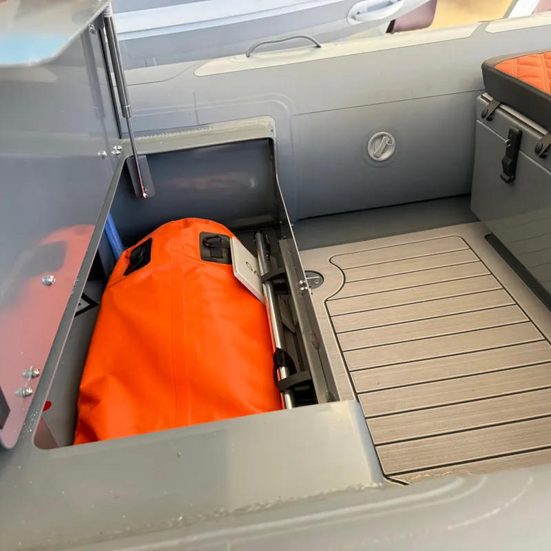 Slide: The Image of Storage compartment of 2025 Highfield Sport 360 boat with orange bag inside. - 11