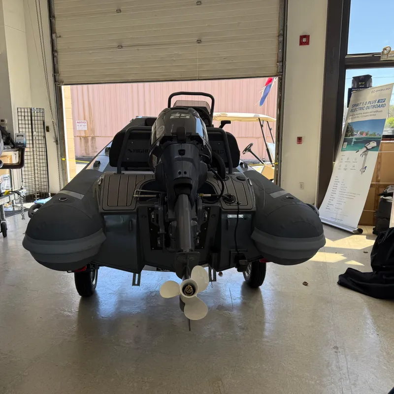 Slide: The Image of 2025 Highfield Sport 360 boat in a garage, rear view with motor and propeller visible. - 4