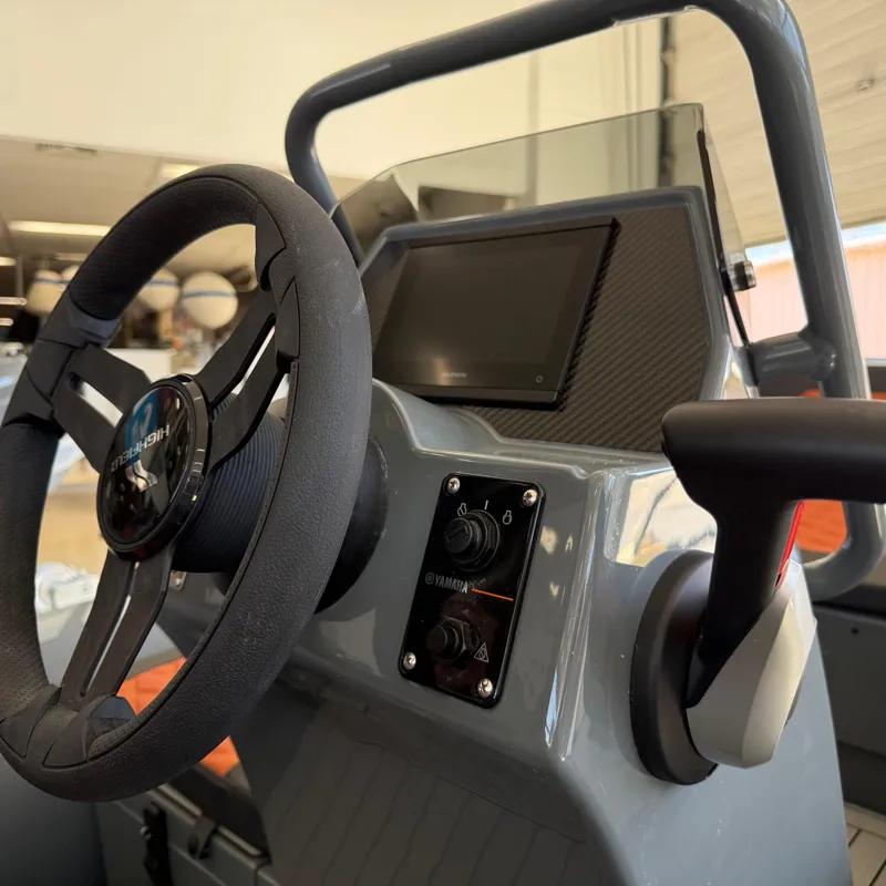 Slide: The Image of Highfield Sport 360 boat dashboard with steering wheel and control panel, 2025 model. - 7