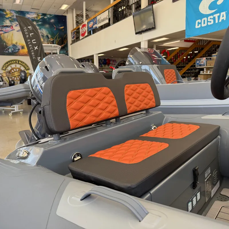 Slide: The Image of 2025 Highfield Sport 360 boat interior with orange quilted seats in showroom. - 9