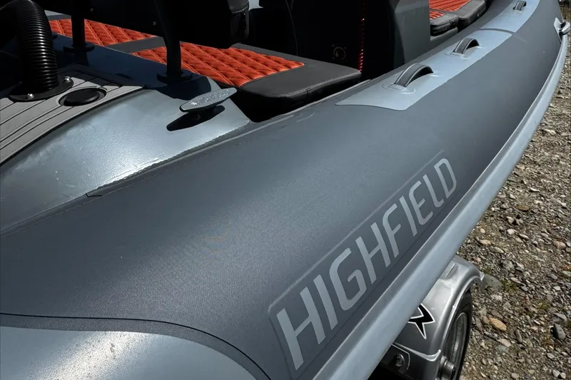Slide: The Image of 2025 Highfield Sport 460 boat with sleek design and red seating accents. - 2