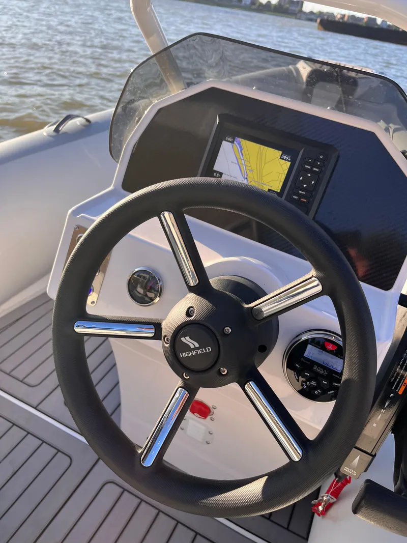 Slide: The Image of 2024 Highfield Classic 420 boat dashboard with steering wheel and navigation display. - 3