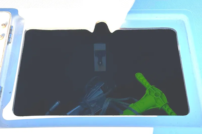 Slide: The Image of Open storage compartment on 2006 KenCraft 230 SEA KING boat with green handle visible. - 14