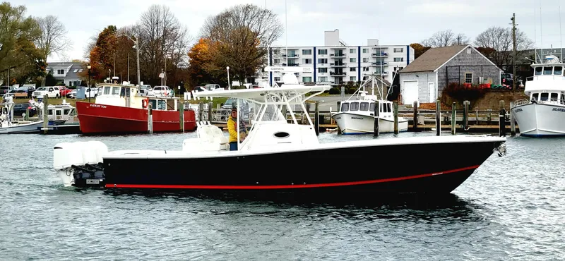 Slide: The Image of 2018 Regulator 34SS boat docked in a marina with other vessels. - 0