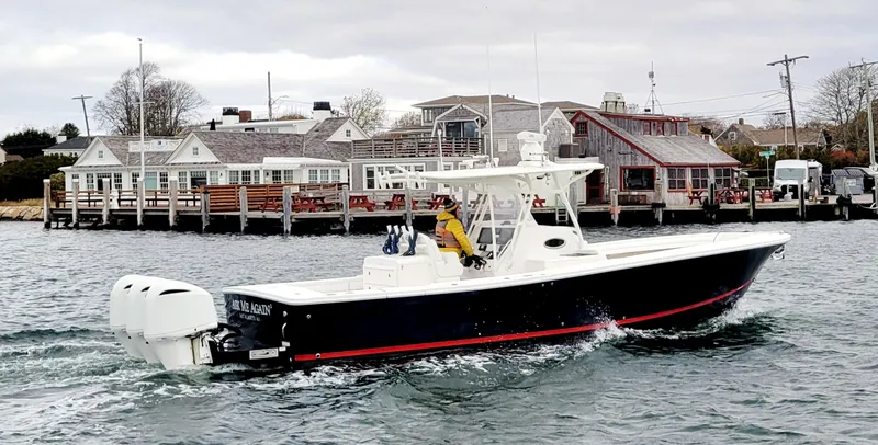 Slide: The Image of 2018 Regulator 34SS boat cruising near coastal buildings. - 1